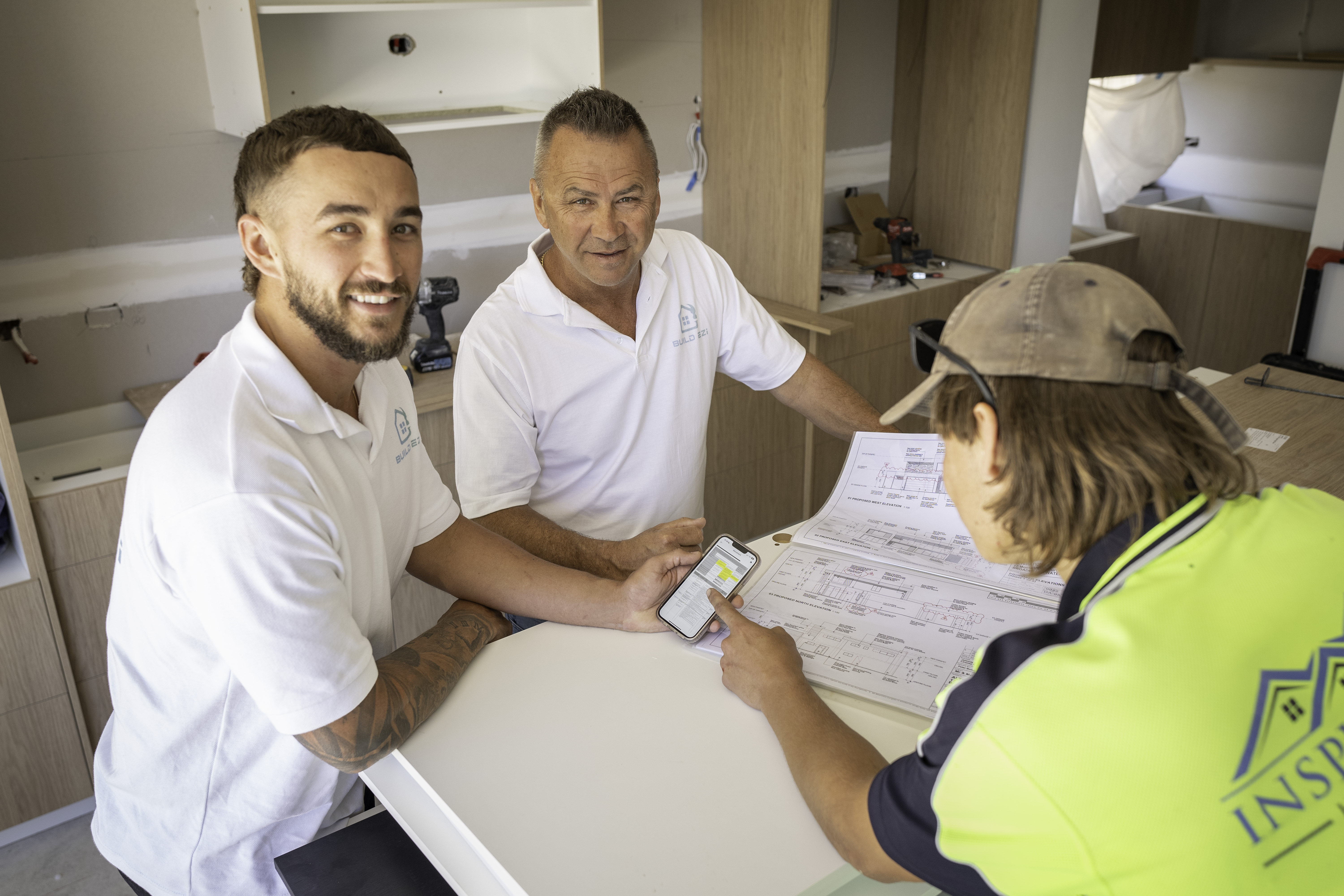 Brandon and Darren Bedford, founders of Build Ezi, on site with a tradie